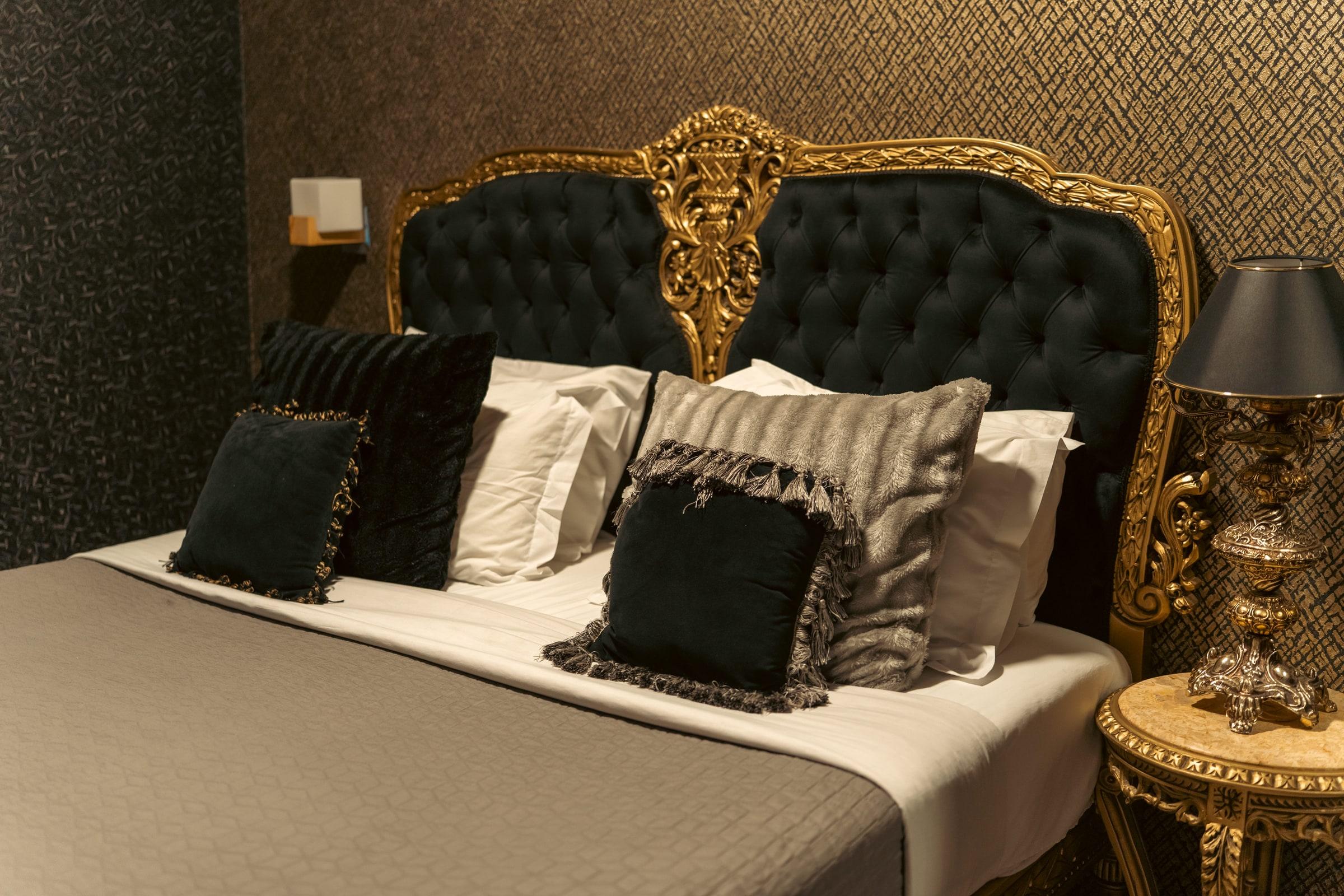 A gold-and-black suite with a tufted baroque bed